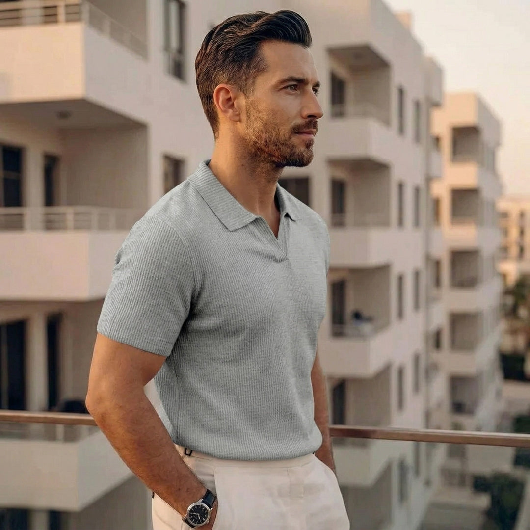 Homme en polo gris clair ajusté à maille côtelée, main dans la poche