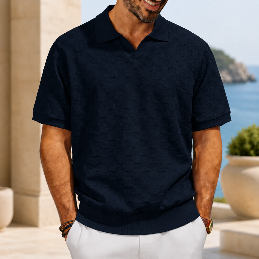 Polo homme bleu marine texturé à col ouvert, décor côtier ensoleillé