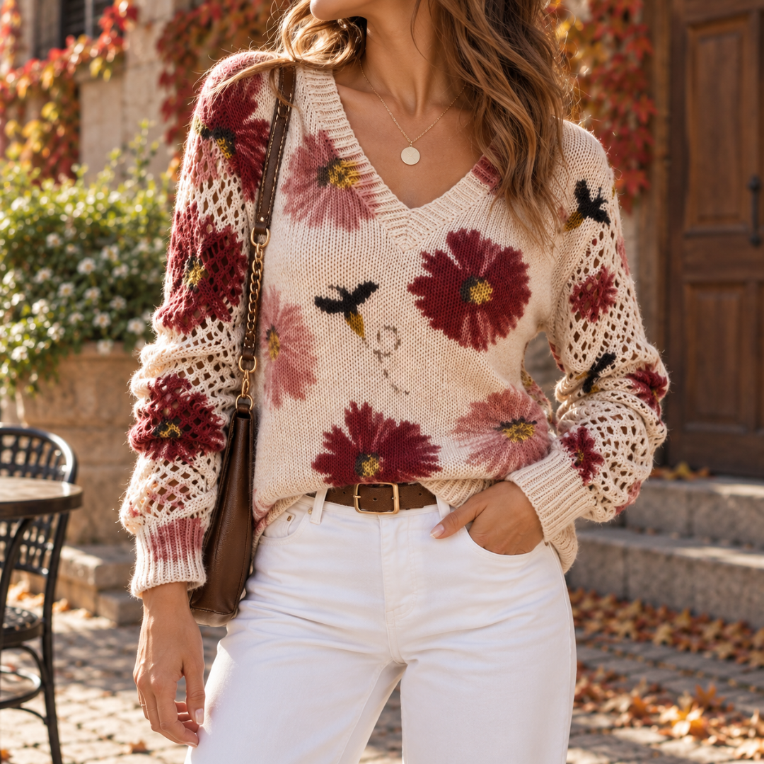 Pull femme fleuri rouge porté avec un pantalon blanc et une ceinture marron