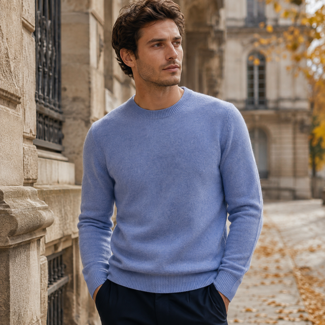 Pull homme bleu à col rond porté avec un pantalon foncé dans la rue