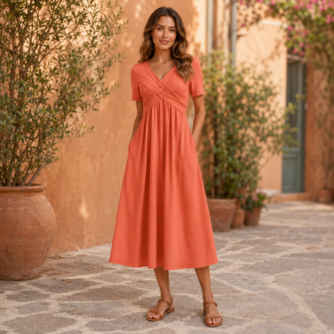 Robe corail portée debout dans une ruelle méditerranéenne ensoleillée