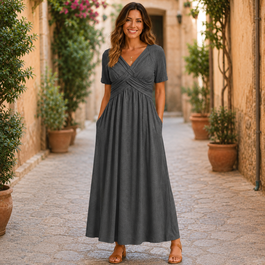 Robe longue gris foncé à taille croisée et poches, portée dans une ruelle