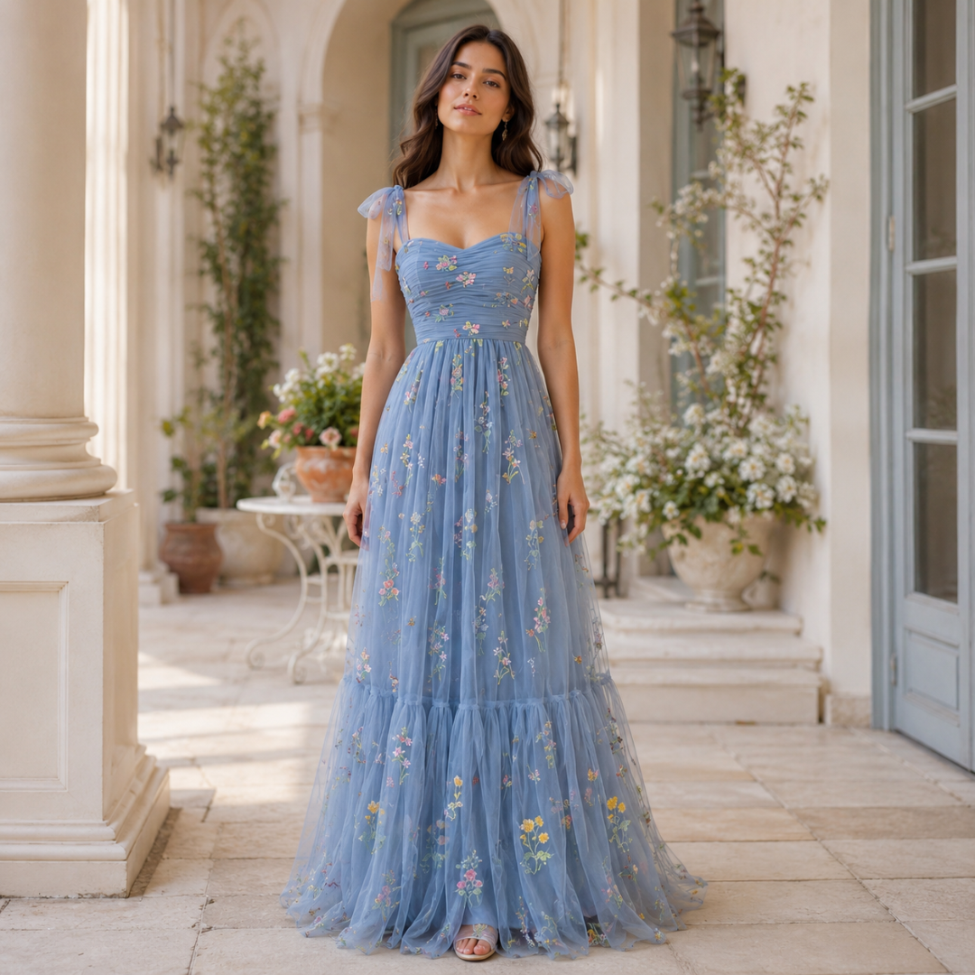 Robe longue en tulle bleu broderies florales portée de face dans un décor de villa méditerranéenne