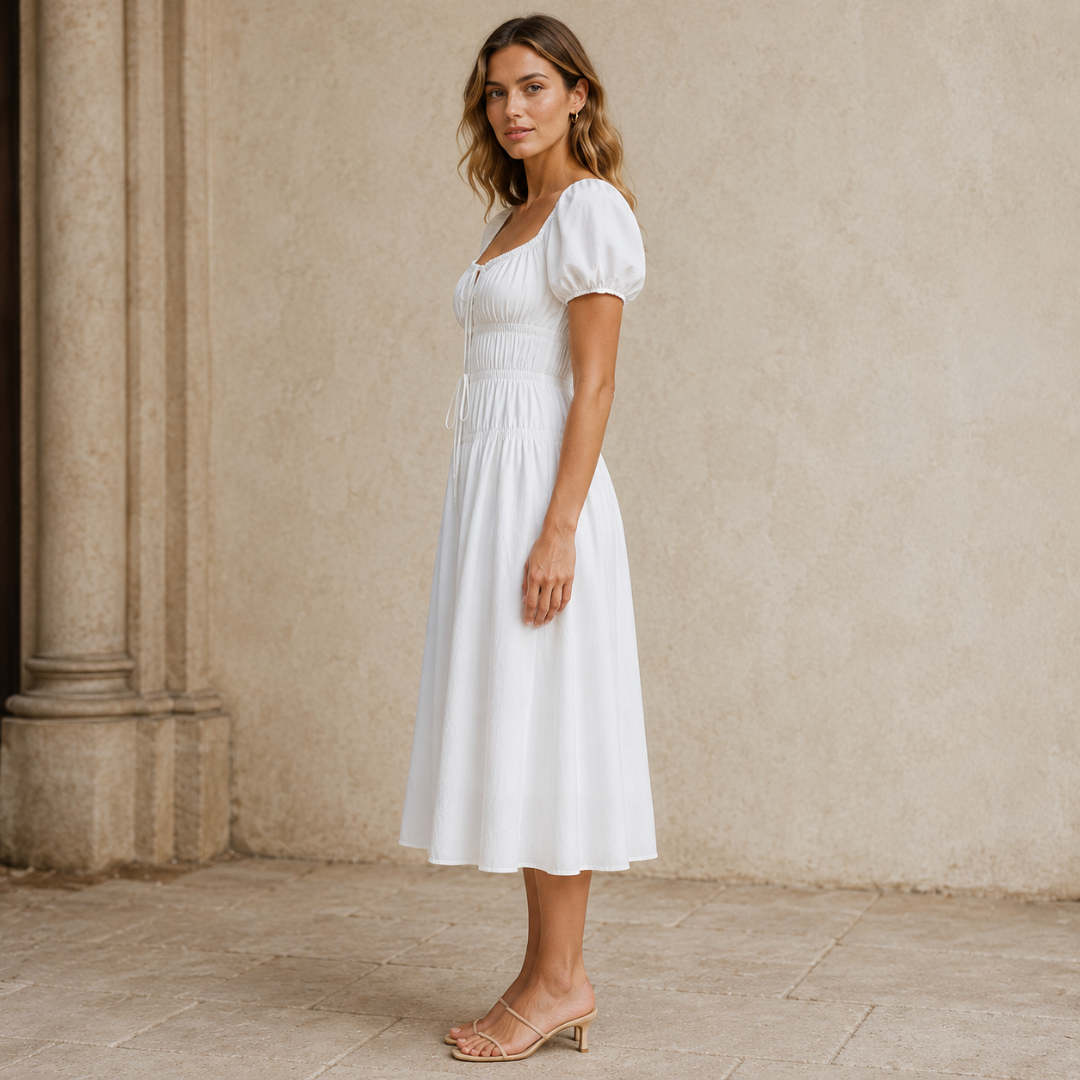 Vue de profil de la robe midi blanche montrant le tombé de la jupe évasée