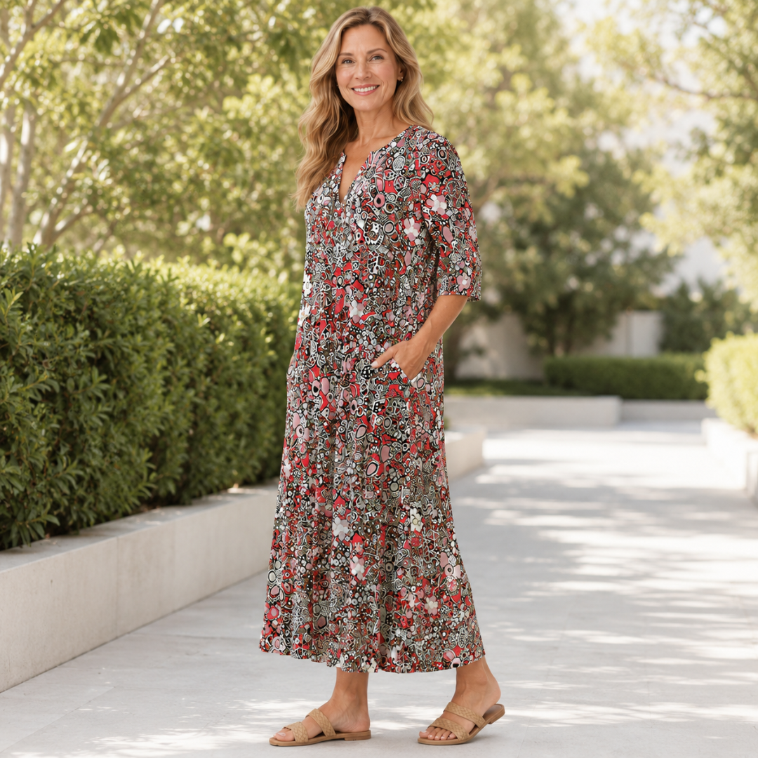 Robe midi fleurie rouge portée en marchant sur une allée ombragée