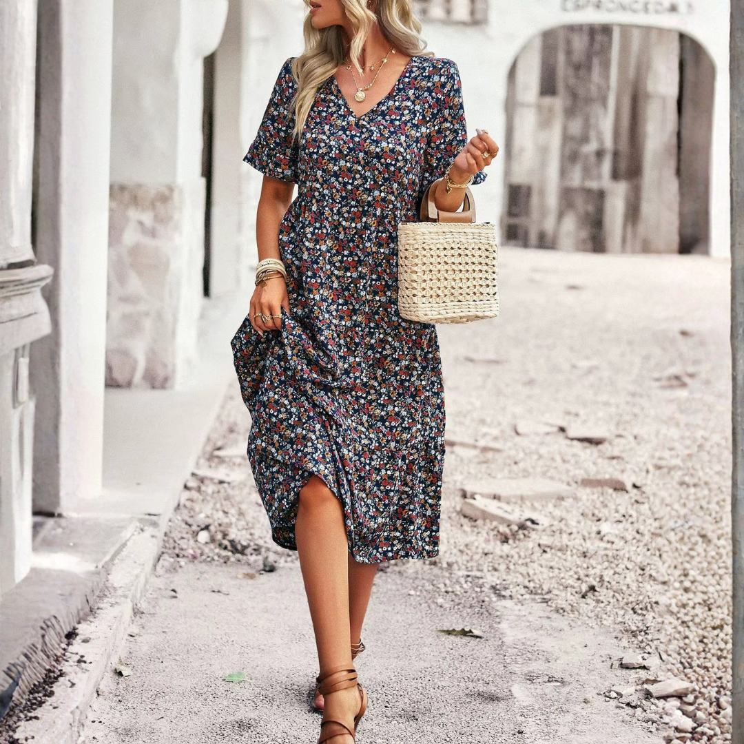 Robe midi fleurie bleue, silhouette entière de face, sac à main blanc