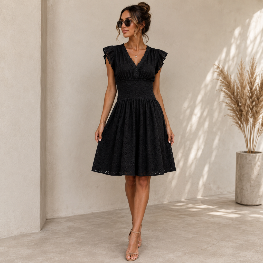 Robe noire à col V, manches volantées et jupe évasée sur fond clair