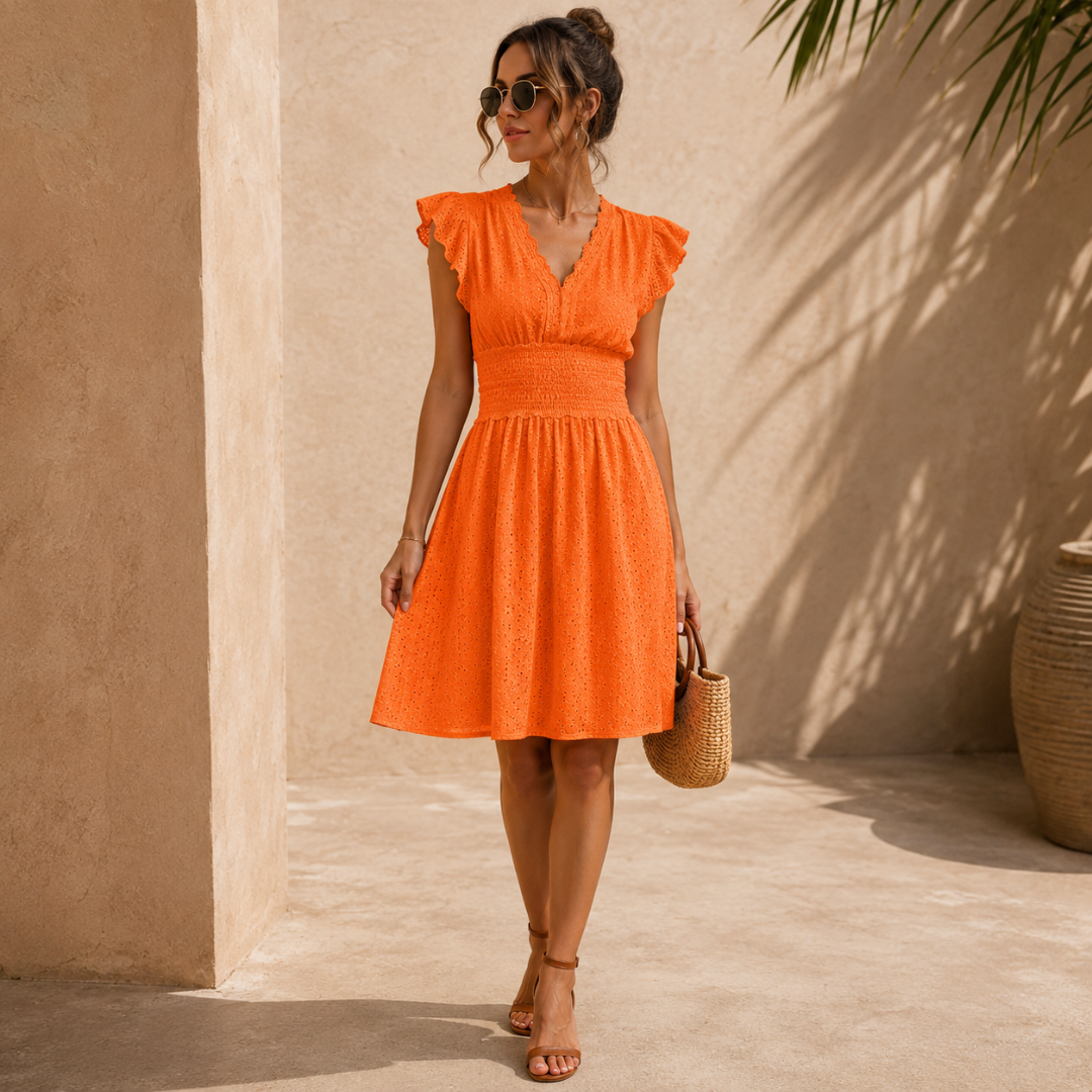 Robe orange à col V et manches volantées portée avec panier en paille