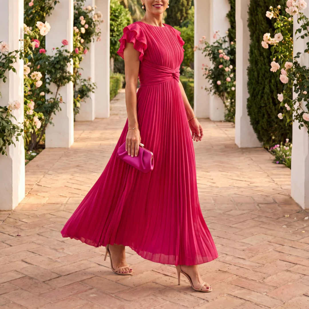 Robe rose plissée vue de trois quarts, manches volantées et jupe flottante