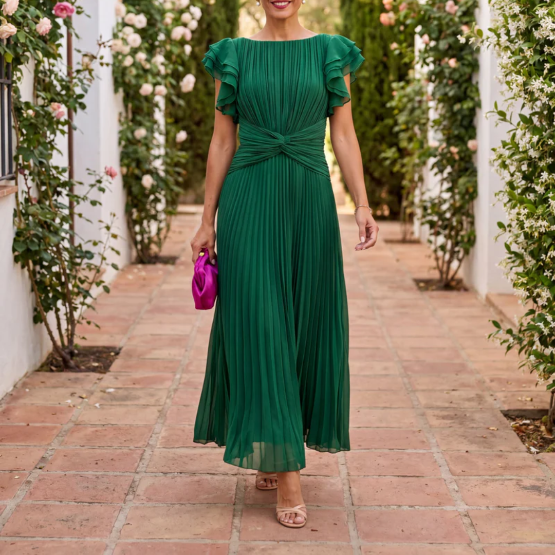 Robe midi plissée verte portée en extérieur, nœud à la taille et manches volantées