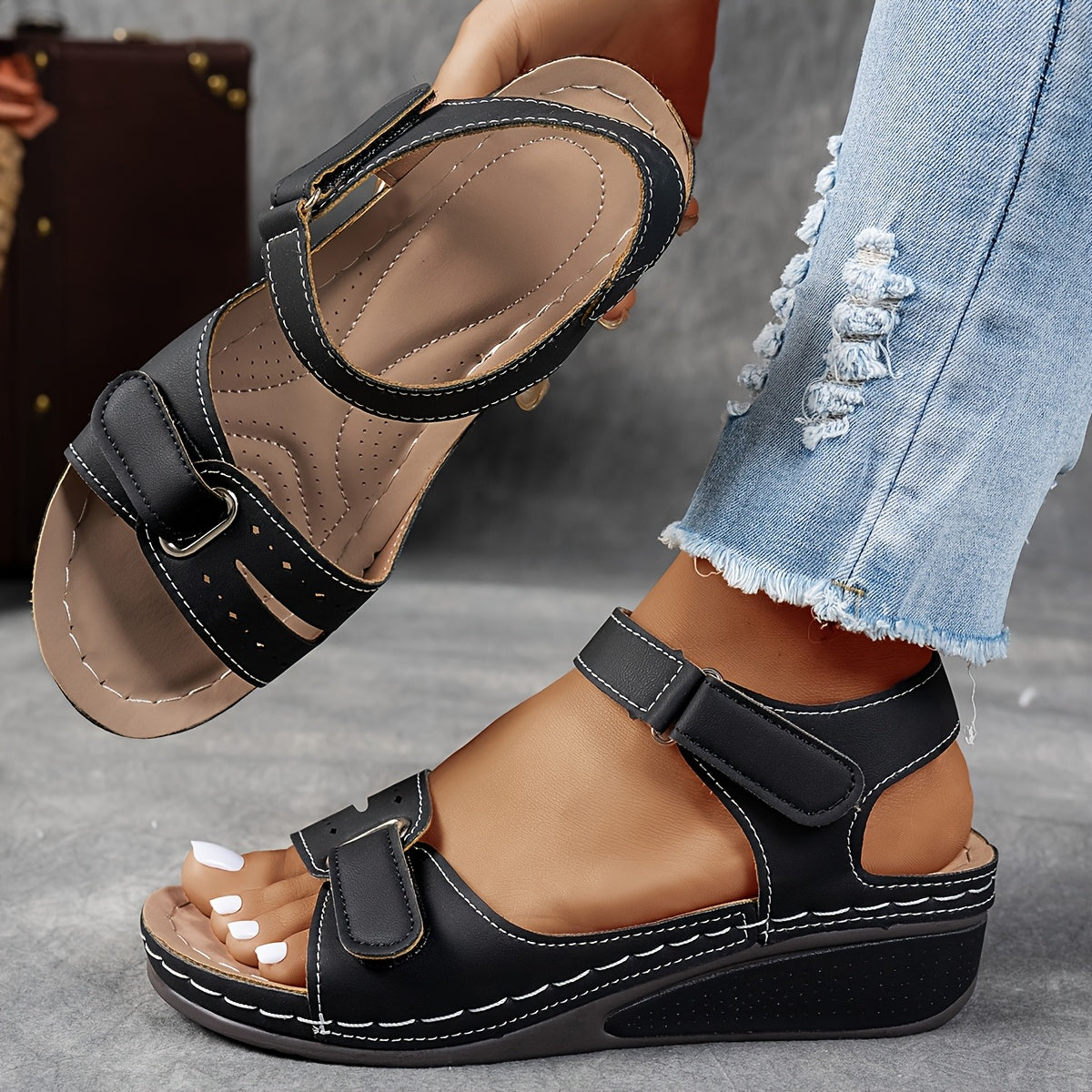 Sandales compensées femme coloris noir portées au pied, vue de côté