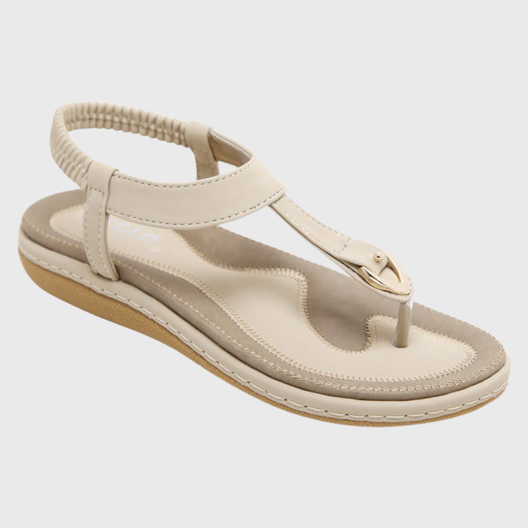 Sandale plate beige isolée sur fond blanc, vue trois quarts