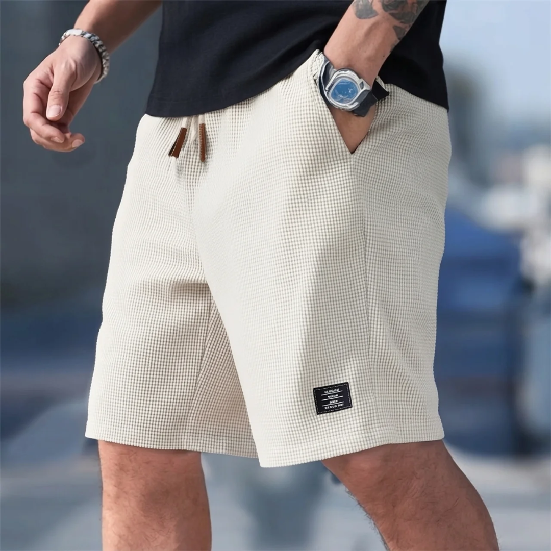 Short homme casual beige porté, cordon de serrage et poche latérale avec montre