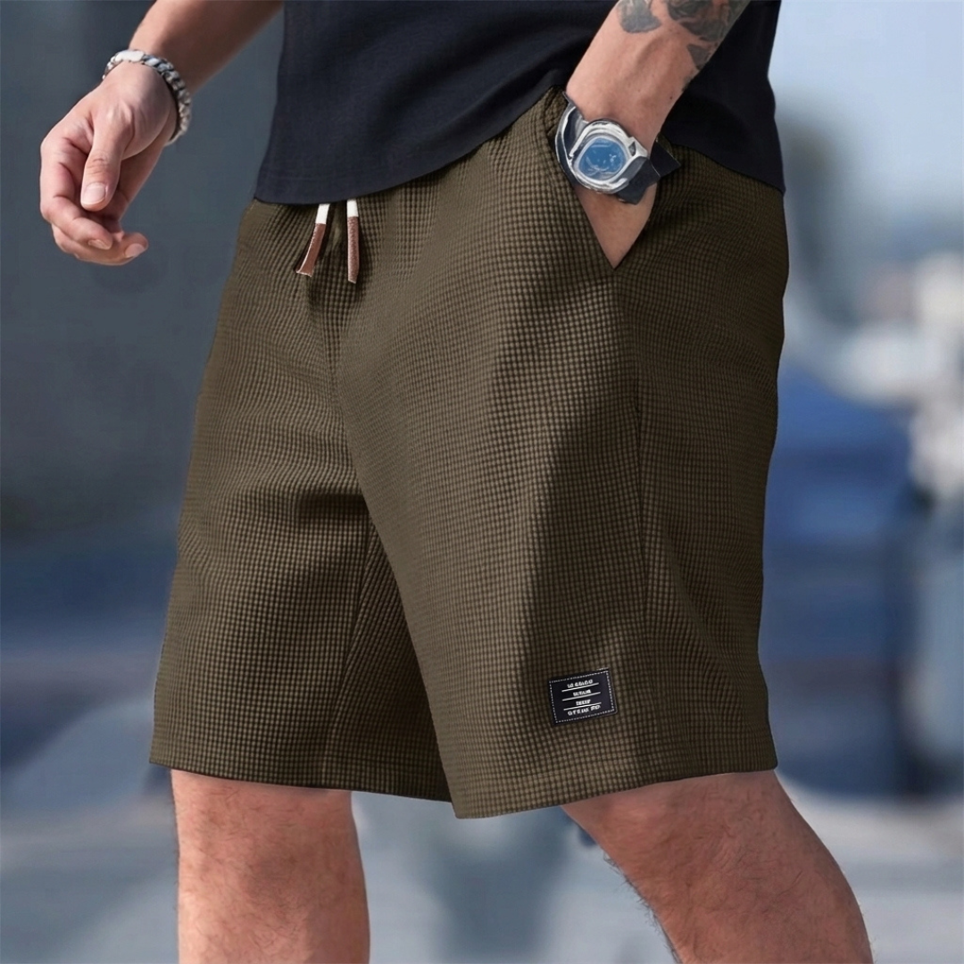 Short homme casual marron porté avec cordon de serrage et étiquette latérale