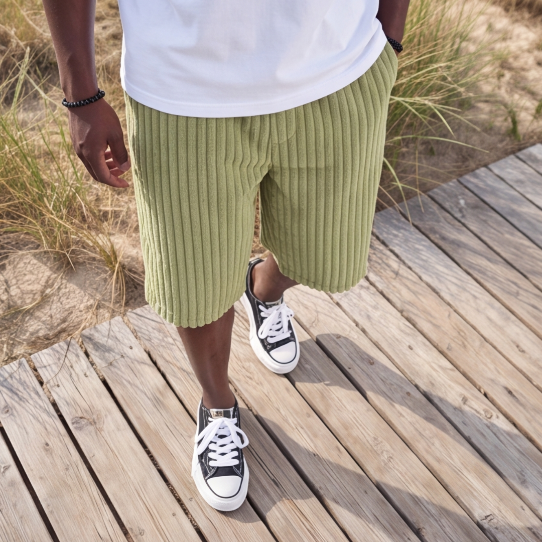Short côtelé vert clair porté avec t-shirt blanc, décor dunes de sable