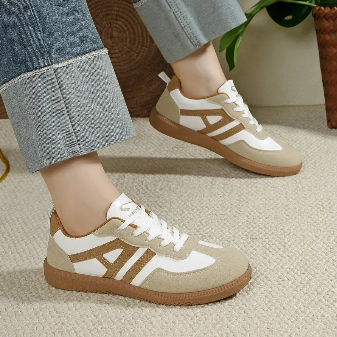 Paire de sneakers casual femme beige portée avec un pantalon clair, vue latérale gauche