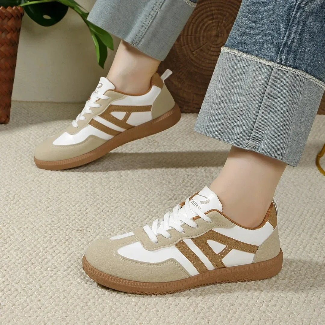 Paire de sneakers casual femme beige portée avec un pantalon clair, vue latérale gauche
