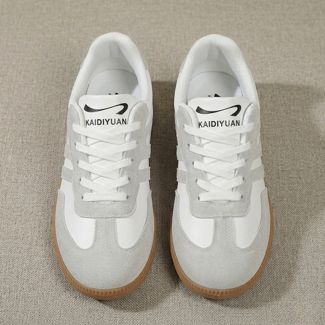 Vue de dessus des deux sneakers beige et blanc posées au sol, lacets blancs plats