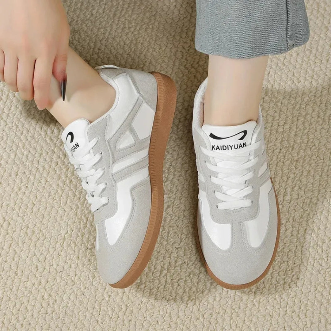 Paire de sneakers femme blanches vue de face, tige lisse et semelle gomme visible
