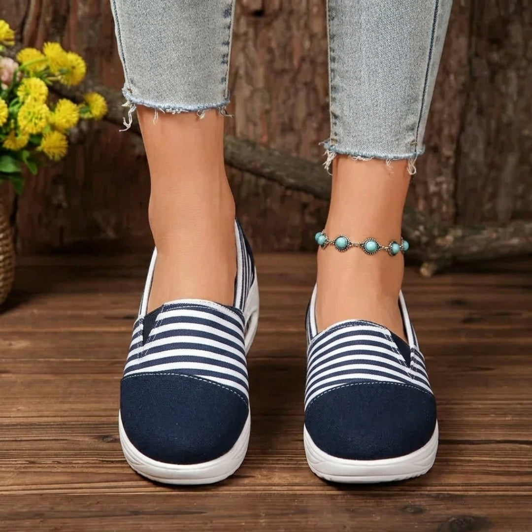 Vue de côté sneaker marine rayée portée avec jean et bracelet cheville