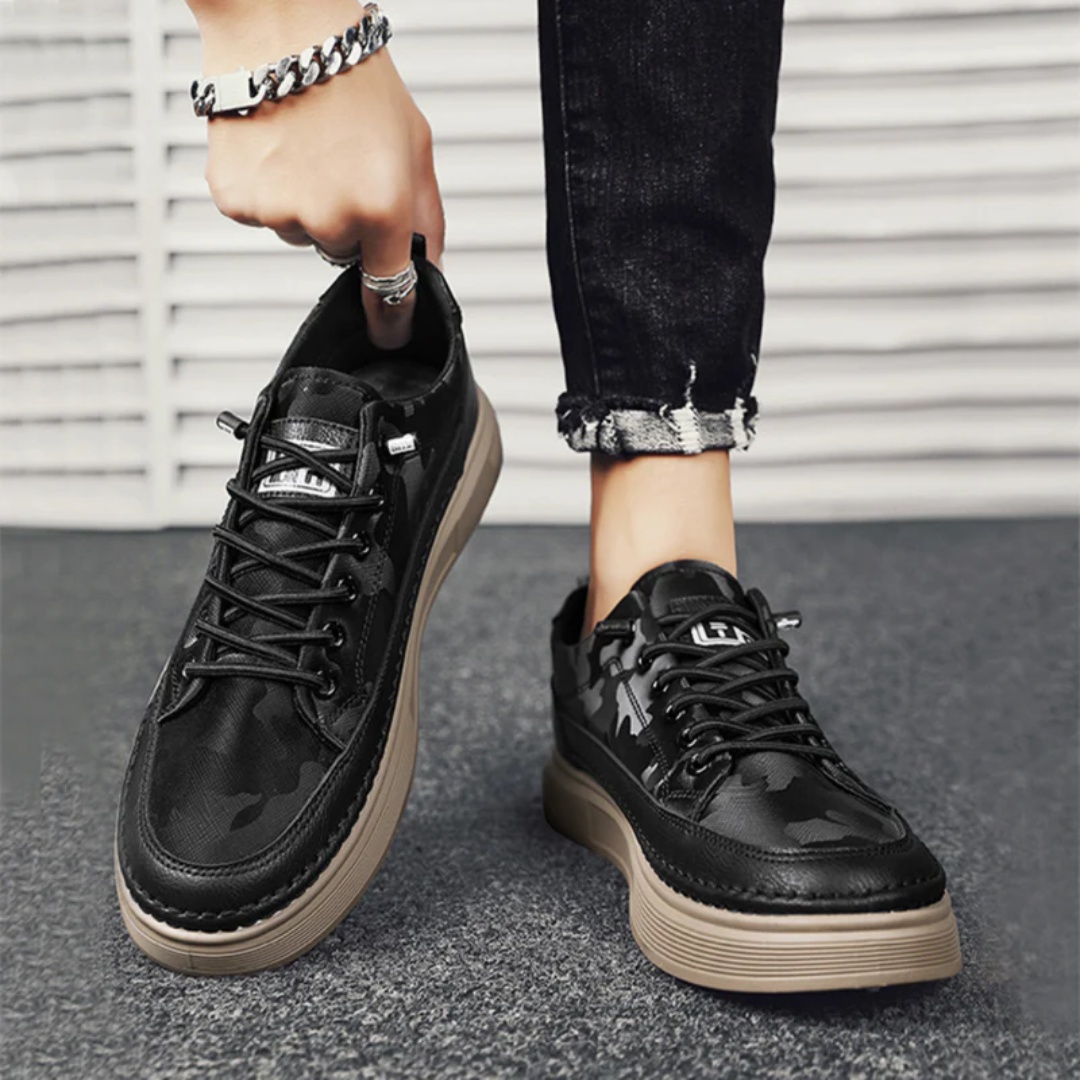 Sneakers homme coloris noir portées, vue de trois quarts en contexte urbain