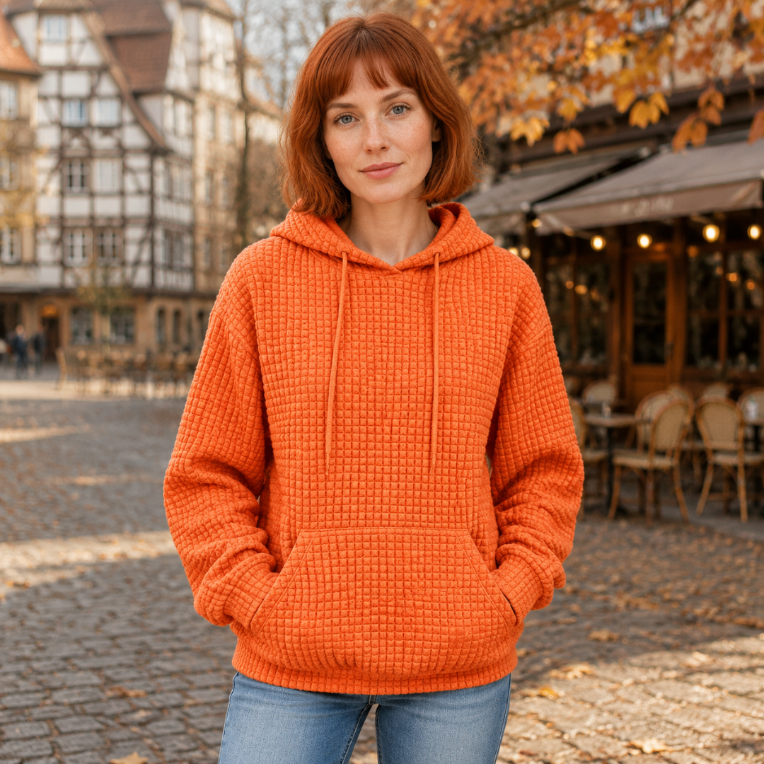 Sweat à capuche orange gaufré porté mains dans la poche kangourou en ville