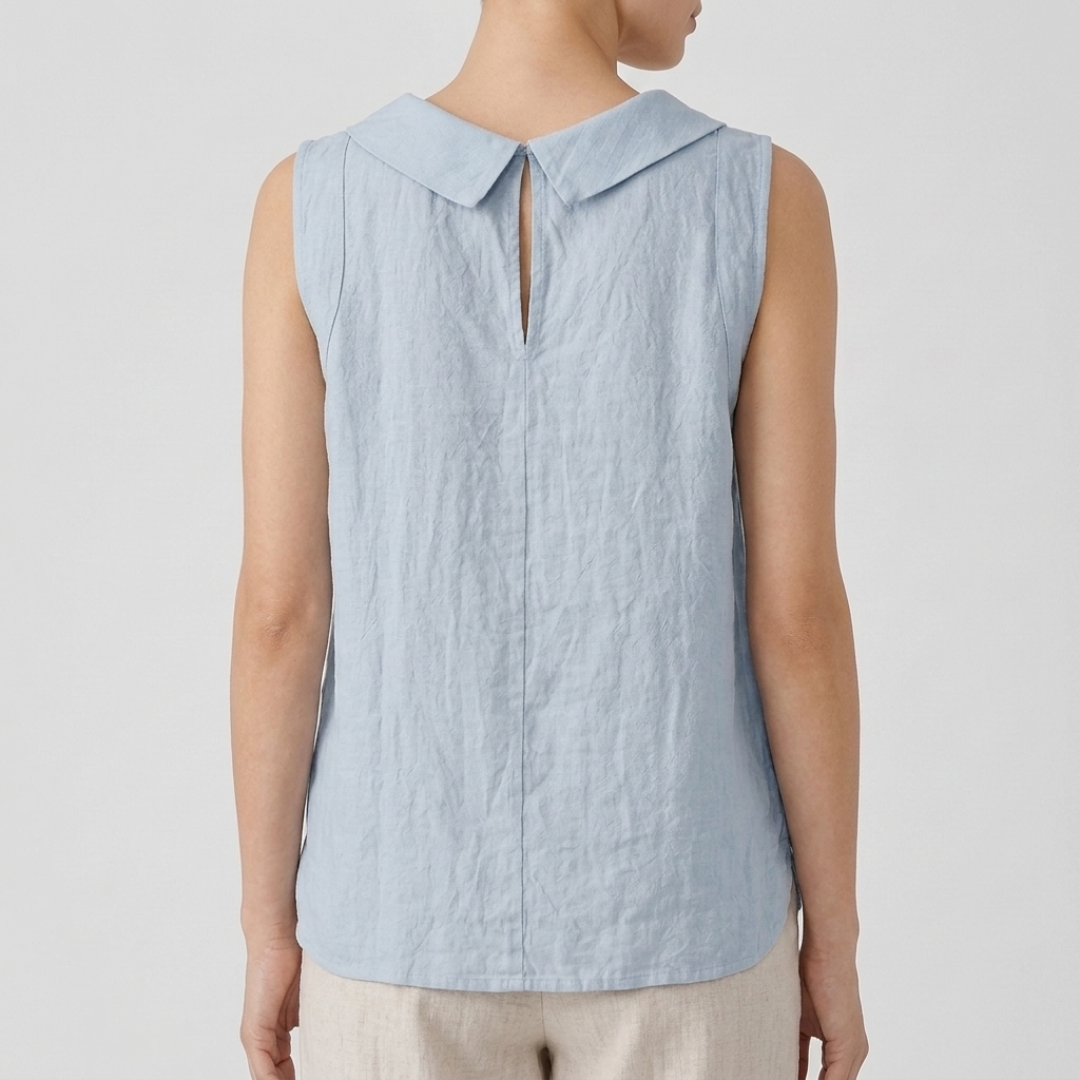 Top femme col bénitier bleu clair porté avec un pantalon beige, vue rapprochée