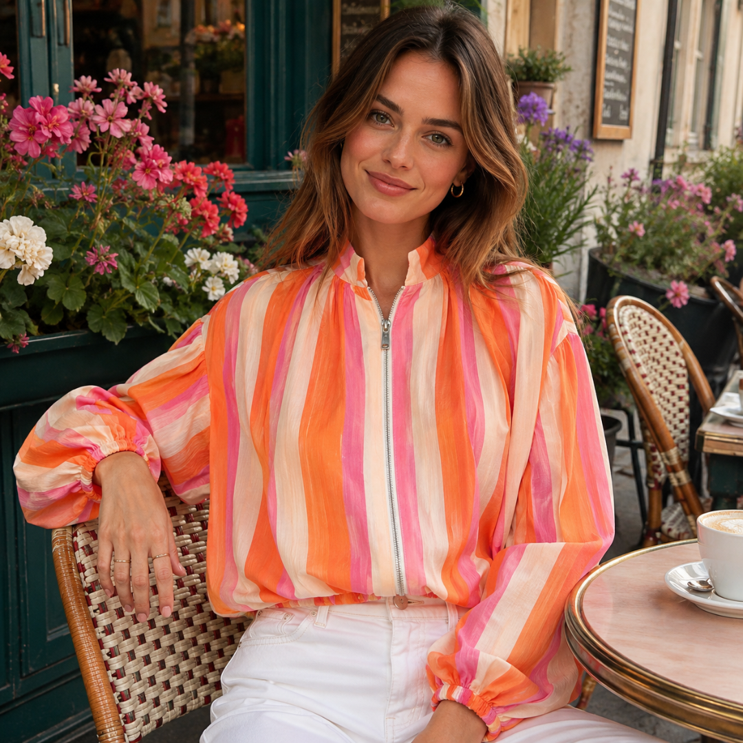 Veste courte multicolore portée en terrasse, fermeture zippée et poignets élastiqués visibles