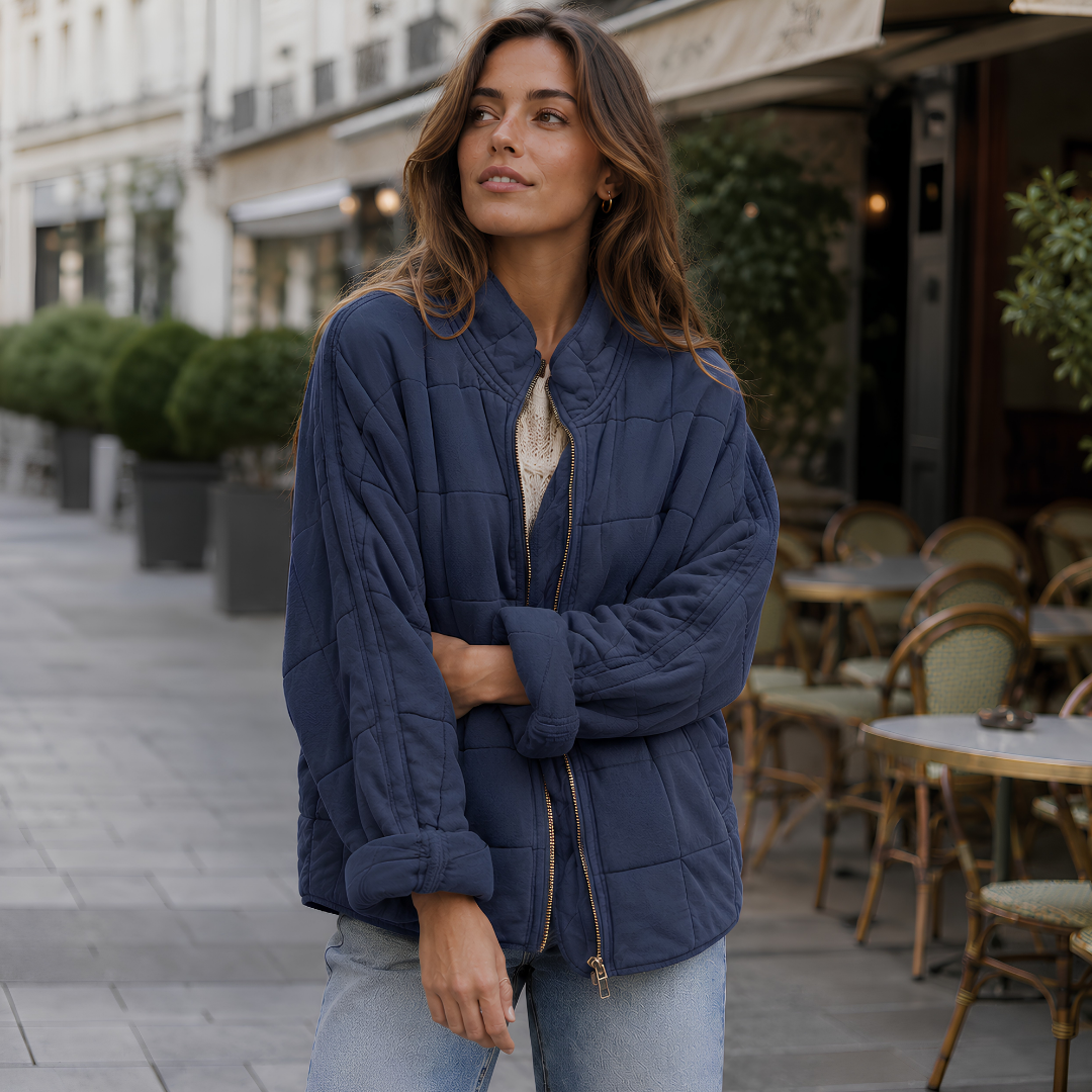 Veste matelassée bleu foncé aux surpiqûres carrées et zip doré ouvert