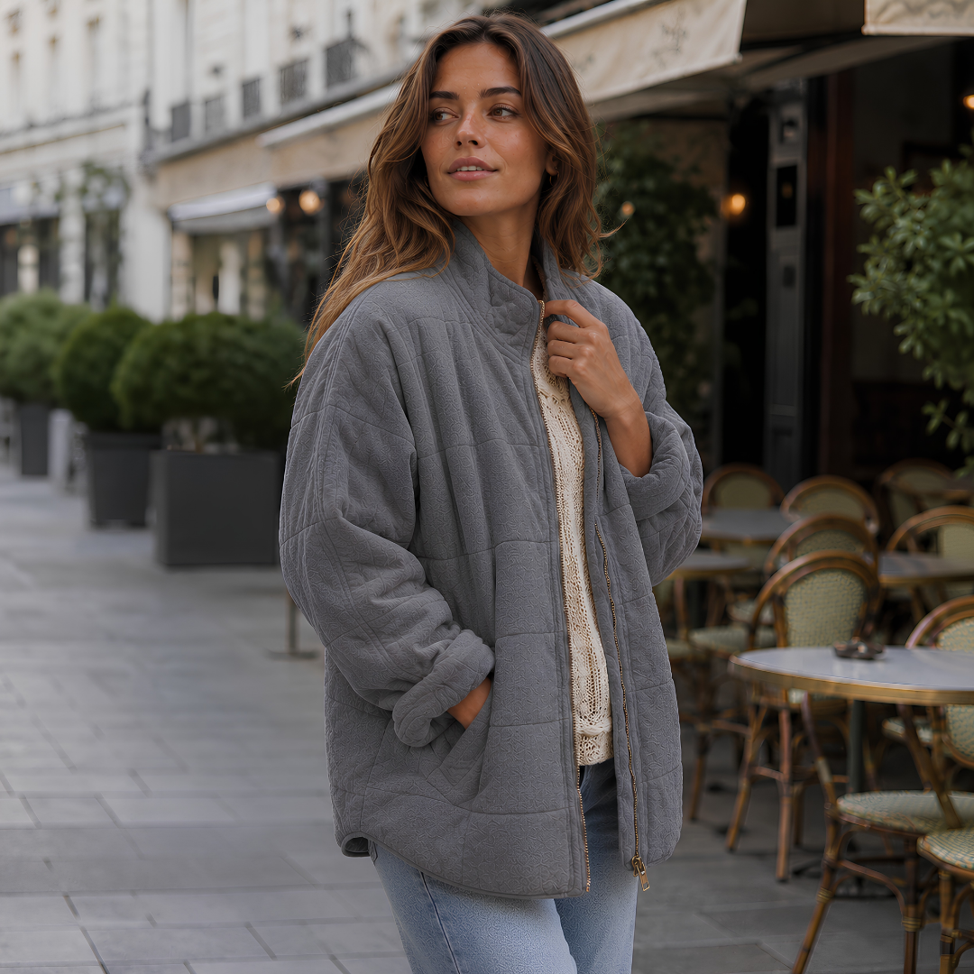 Veste matelassée gris foncé de trois quarts, main dans la poche latérale