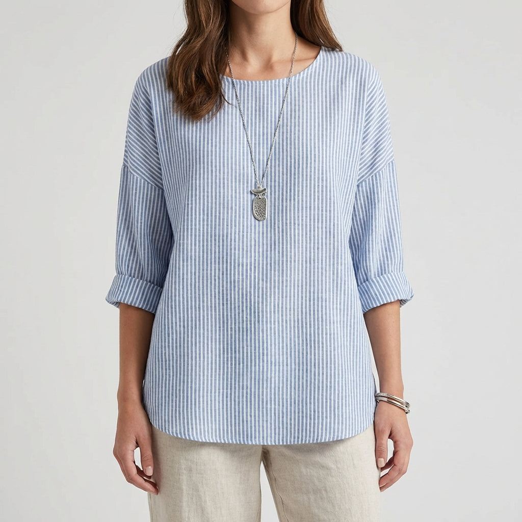Femme portant une blouse rayée bleu ciel à manches trois-quarts avec un collier