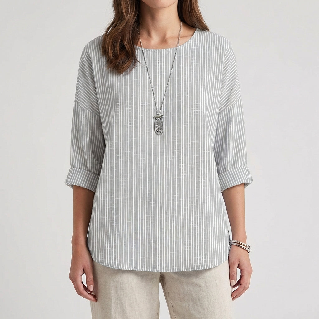 Femme portant une blouse rayée grise à manches trois-quarts avec un collier

