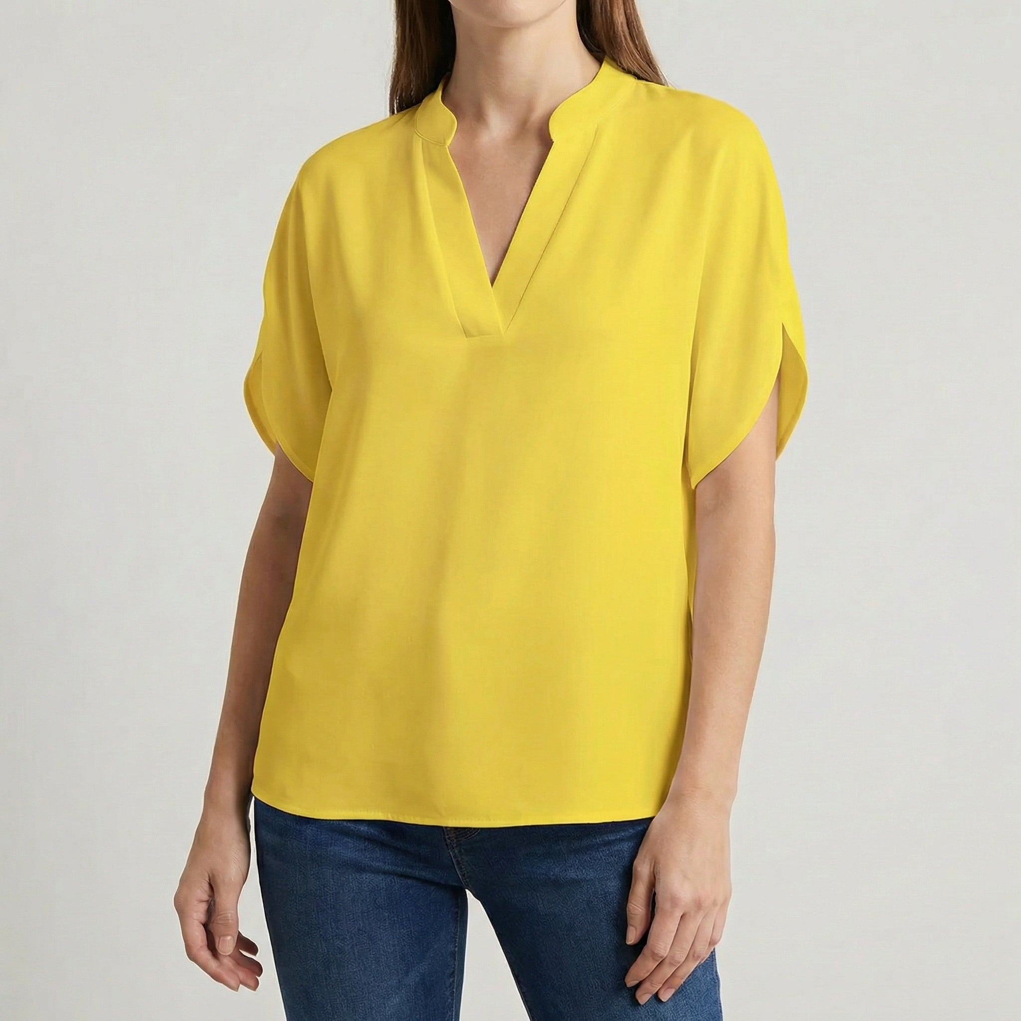 Blouse femme col en V avec manches fendues en jaune soleil, portée avec un jean bleu