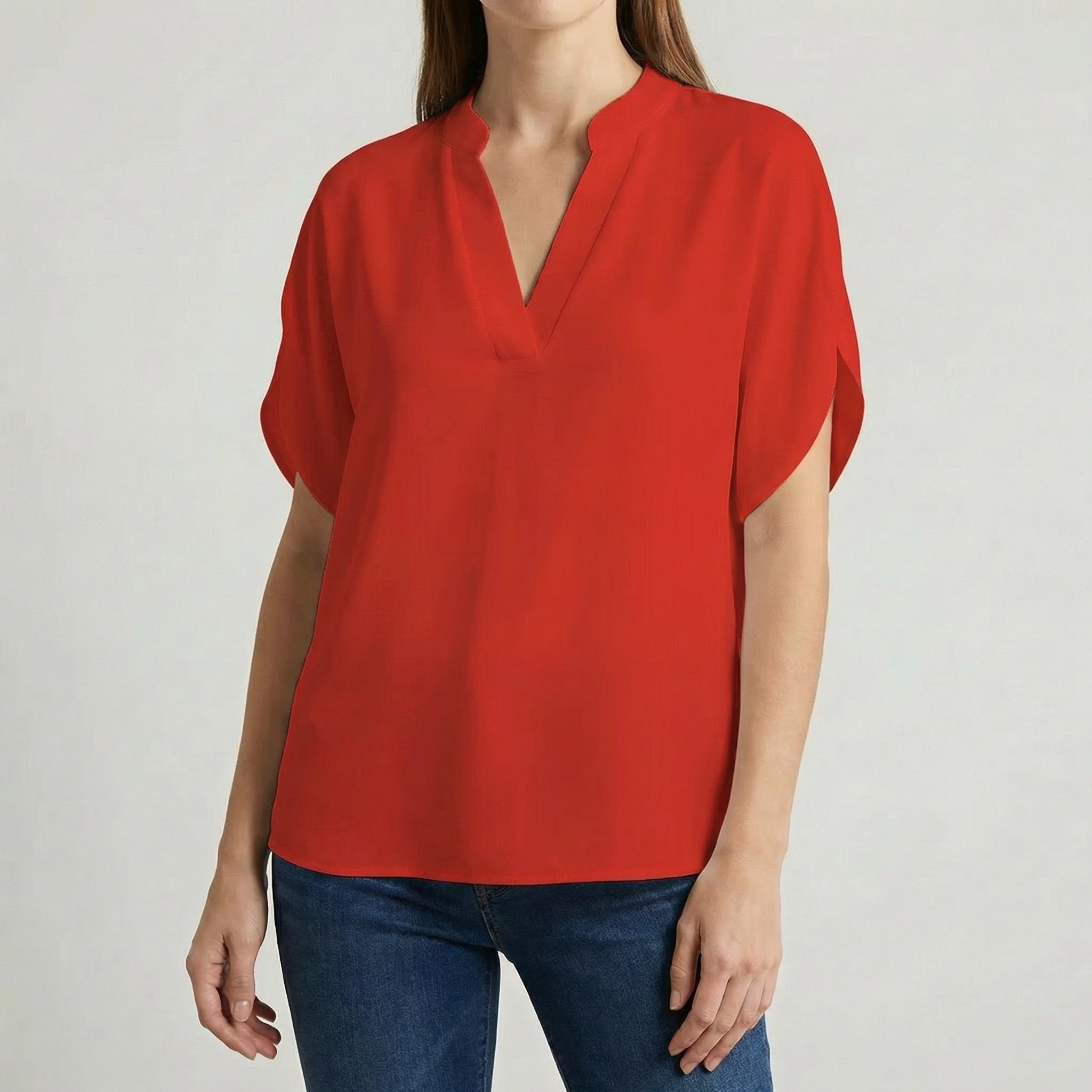 Blouse femme col en V avec manches fendues en rouge vif, portée avec un jean bleu