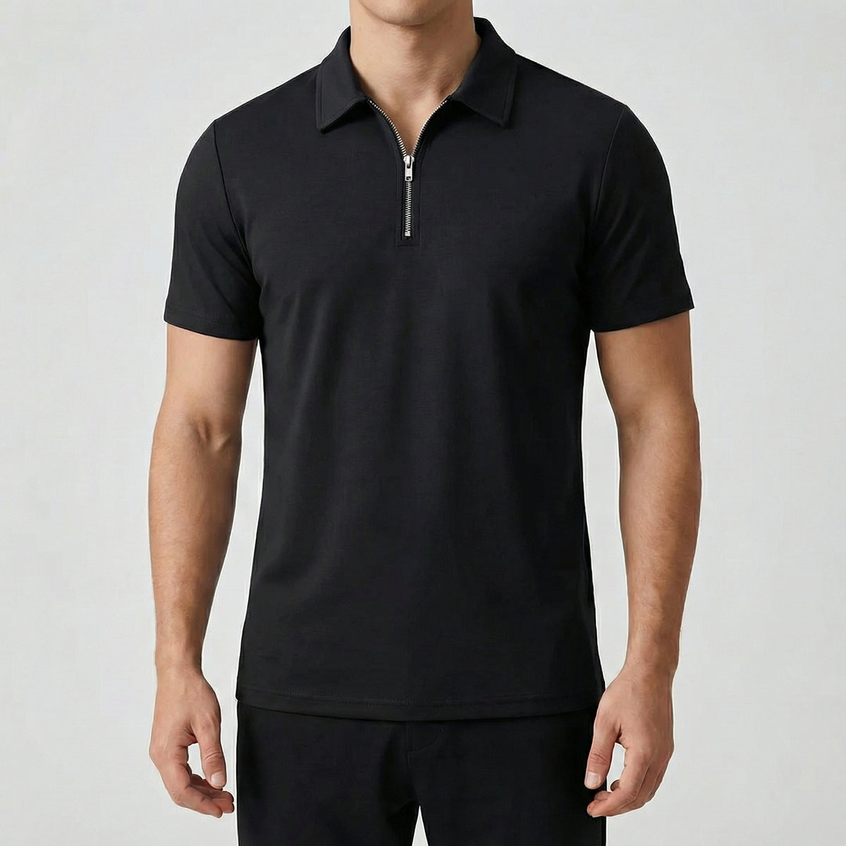 Polo zippé noir à manches courtes, fermeture éclair argentée, coupe slim, porté par un mannequin masculin, fond gris