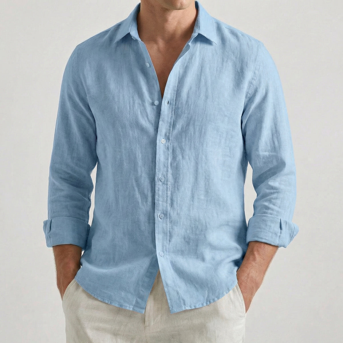 Chemise homme à manches longues et col rabattu, coloris bleu ciel, portée par un mannequin masculin dans une pose décontractée sur fond gris clair