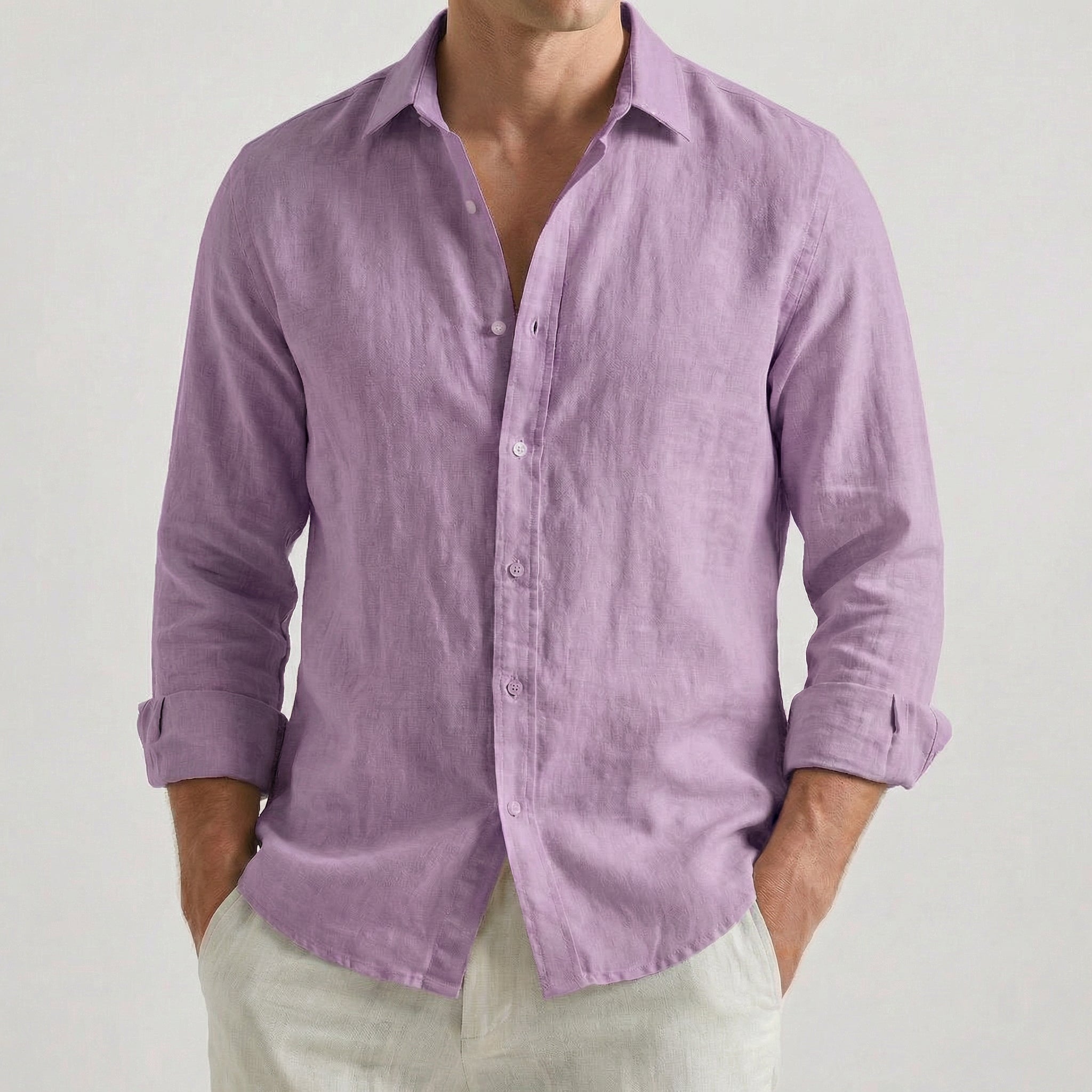 Chemise homme en lin à manches longues et col rabattu, coloris violet, portée par un mannequin masculin dans une pose décontractée sur fond gris clair.
