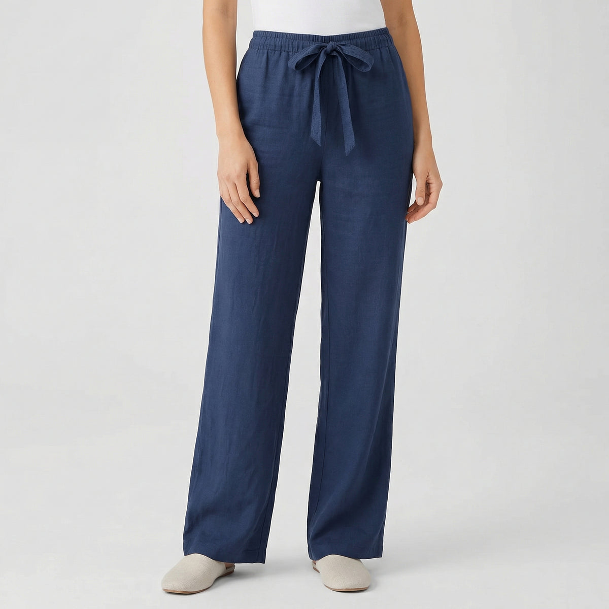 Pantalon fluide femme bleu marine avec taille élastique et cordon, coupe droite, porté par mannequin, fond gris clair