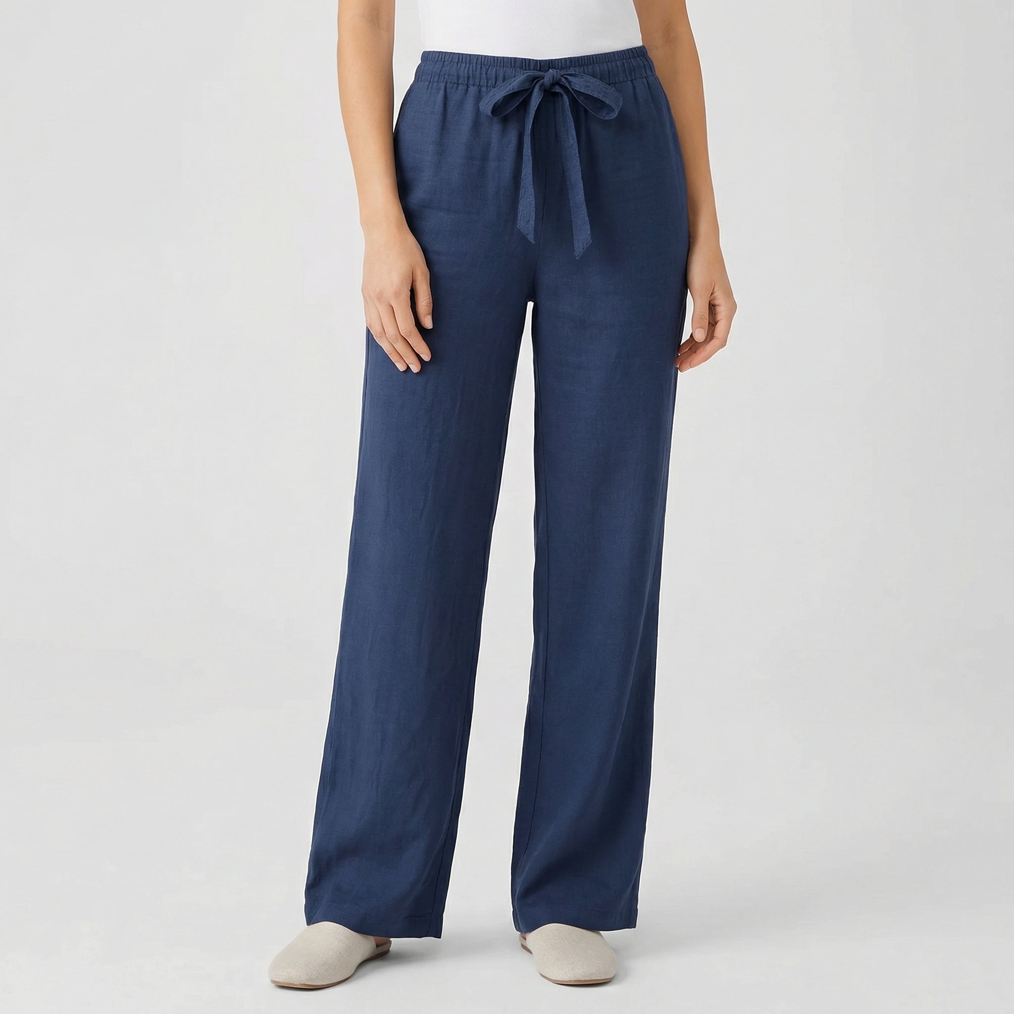 Pantalon fluide femme bleu marine avec taille élastique et cordon, coupe droite, porté par mannequin, fond gris clair