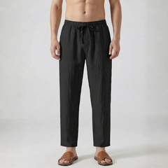 Pantalon en lin pour homme coloris noir avec cordon de serrage et coupe droite, porté avec des sandales marron