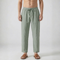 Pantalon en lin pour homme coloris vert sauge avec cordon de serrage et coupe droite, porté avec des sandales marron