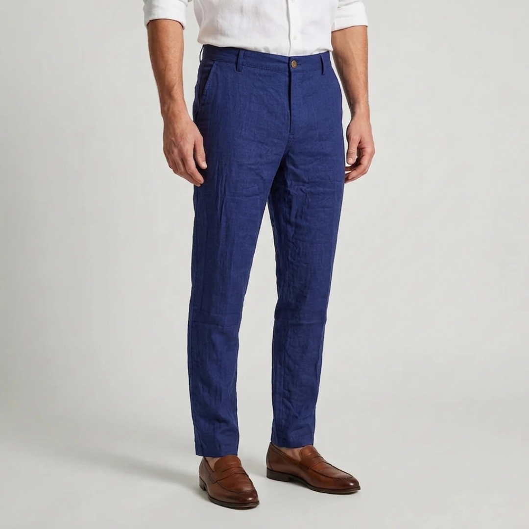 Pantalon bleu marine à pinces, coupe slim effilée, porté avec une chemise blanche et des mocassins en cuir marron.