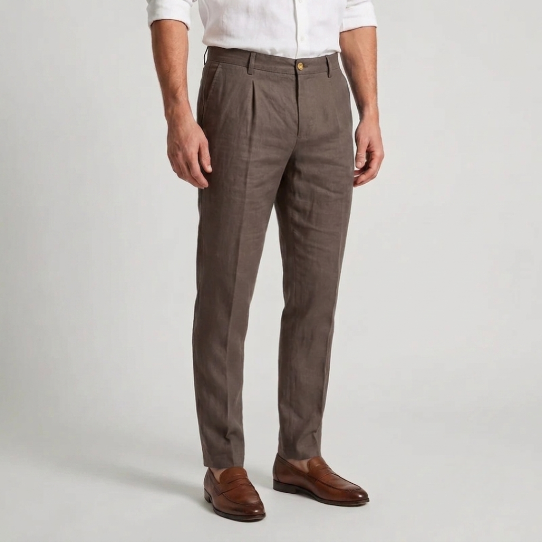 Pantalon marron à pinces, coupe slim effilée, porté avec une chemise blanche et des mocassins en cuir marron