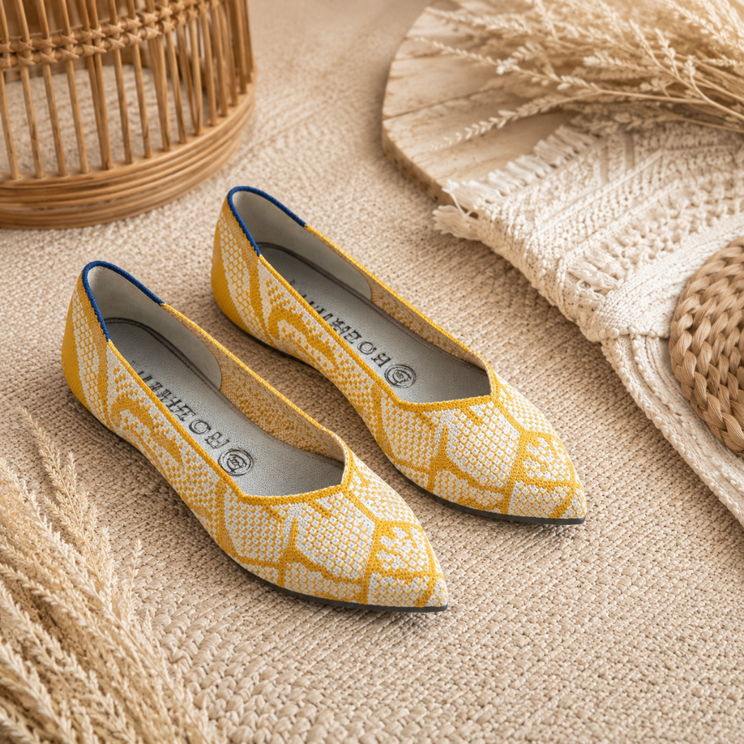 Ballerines jaunes à motifs blancs, intérieur clair visible, disposées sur un tapis beige