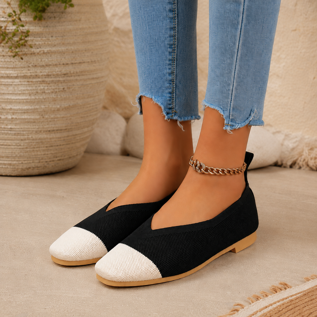 Ballerines noires portées de profil, bout contrastant clair et échancrure en V nette