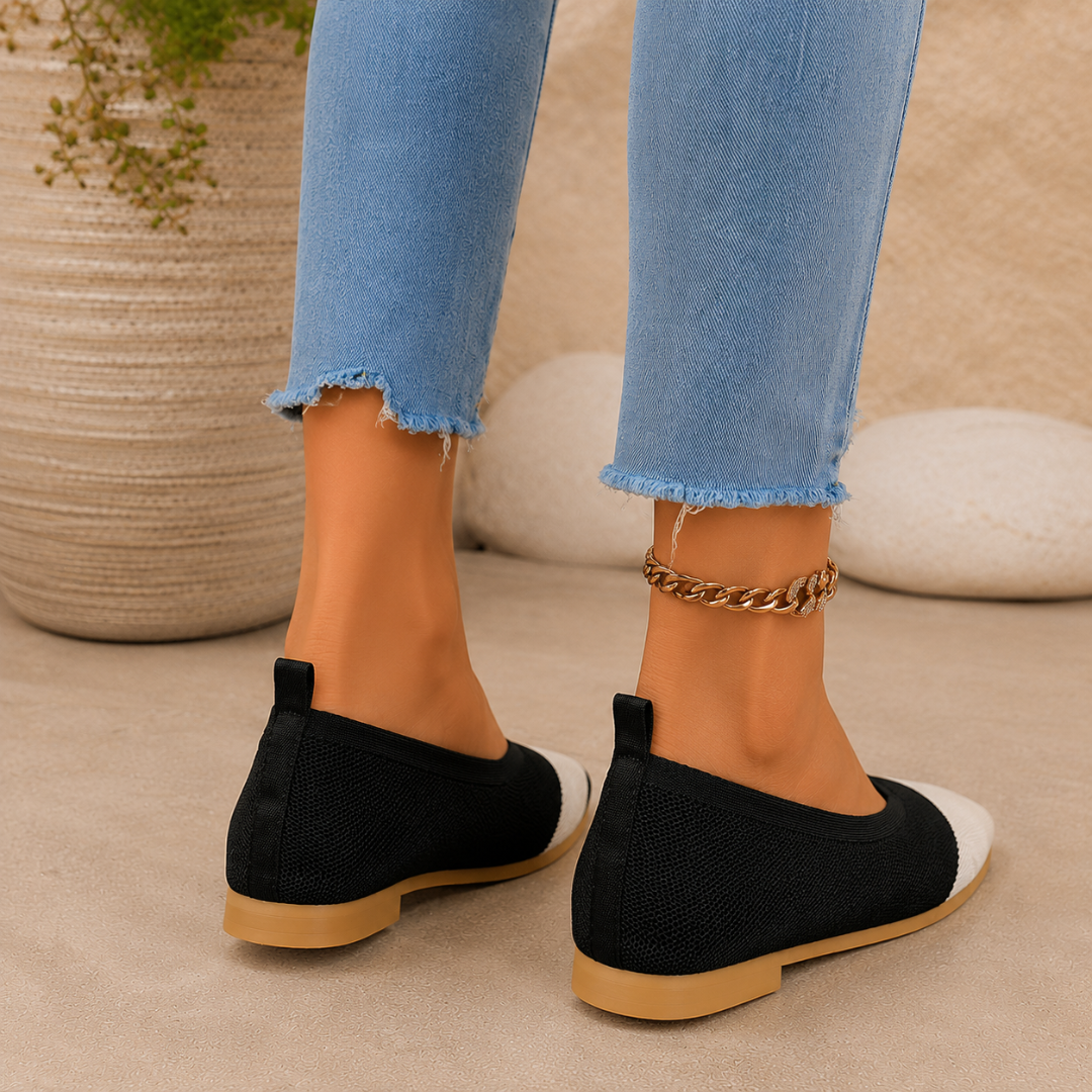 Ballerines noires vues de dos, talon plat, patte d'enfilage et semelle camel