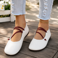 Ballerines plates blanches portées avec brides croisées bordeaux et bout carré arrondi