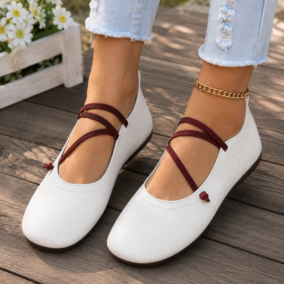 Ballerines plates blanches en gros plan, bout carré souple et brides élastiques croisées