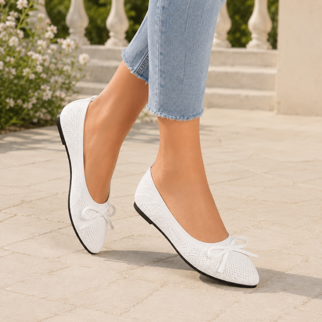 Ballerines blanches plates en mouvement, décolleté bas dégageant la cheville