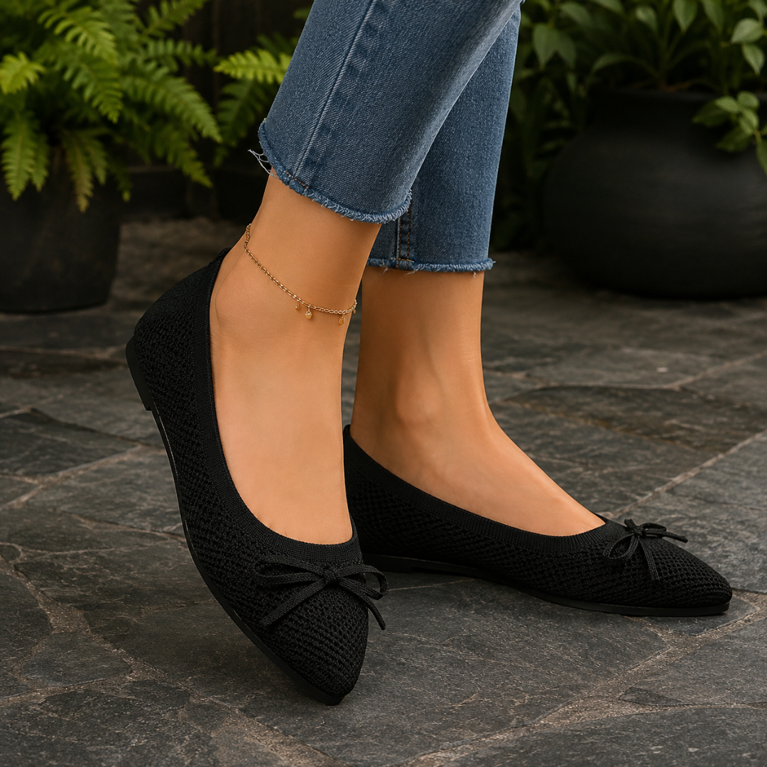 Ballerines noires à bout pointu et nœud, pantalon bleu et chaîne de cheville dorée